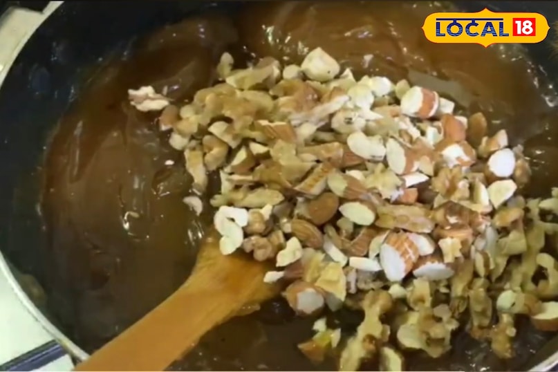 हलवा बनाना अब कड़ाही को आंच से उतार लें धीरे-धीरे, थोड़ा-थोड़ा करके तैयार गर्म चाशनी को सूजी-मावा के मिश्रण में डालें, और साथ ही तेजी से चलाते रहें ताकि गठ्ठे न बनें जब सारी चाशनी मिल जाए, तो कड़ाही को वापस मध्यम आंच पर रख दें। लगातार चलाते रहें। मिश्रण धीरे-धीरे गाढ़ा होने लगेगा और घी छोड़ने लगेगा।